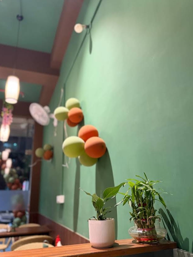 Cozy cafe corner with green walls and plants